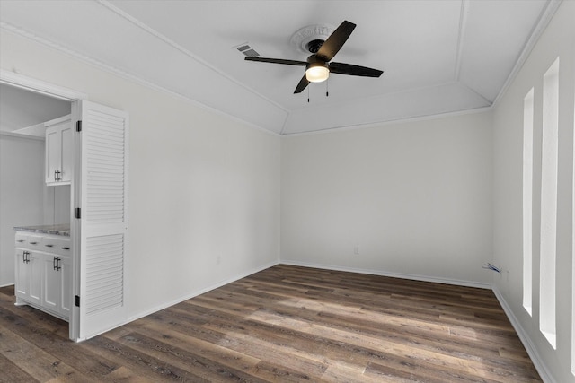 empty room featuring visible vents, baseboards, a ceiling fan, dark wood-style floors, and crown molding