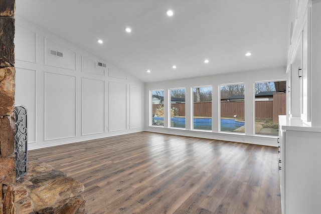 unfurnished living room with lofted ceiling and dark wood-type flooring