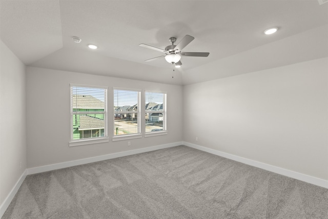 spare room with lofted ceiling, carpet, a ceiling fan, and baseboards