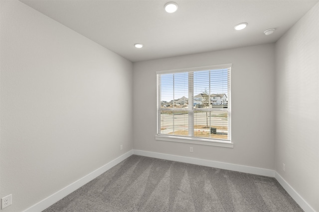 unfurnished room with recessed lighting, dark carpet, and baseboards