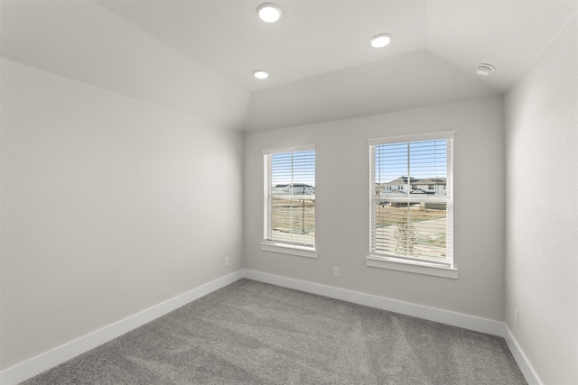 empty room with lofted ceiling, light colored carpet, baseboards, and recessed lighting