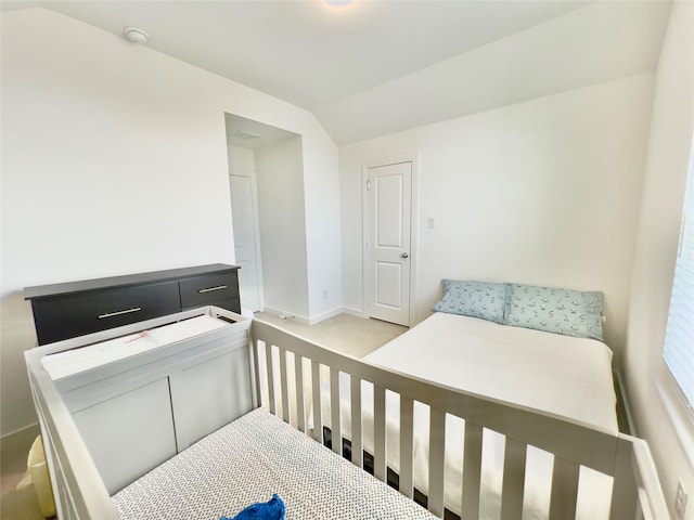 bedroom with baseboards, lofted ceiling, and light colored carpet