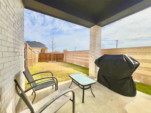 view of patio with area for grilling and a fenced backyard