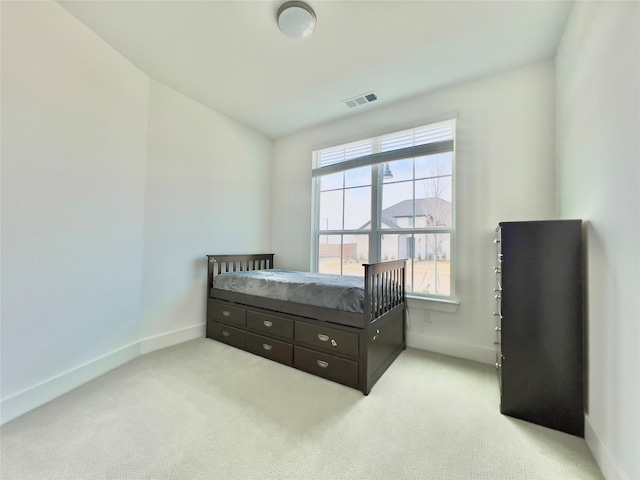 bedroom featuring light carpet and multiple windows