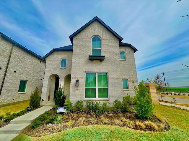 view of front of house featuring brick siding and a front lawn