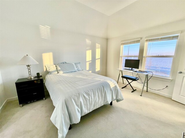 carpeted bedroom featuring lofted ceiling and baseboards