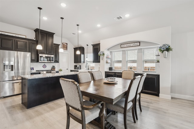 dining room featuring lofted ceiling, recessed lighting, visible vents, baseboards, and light wood-type flooring