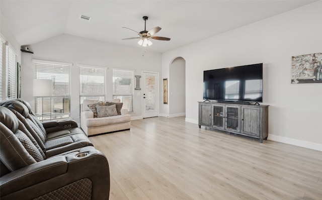 living area featuring visible vents, arched walkways, lofted ceiling, light wood-style flooring, and ceiling fan