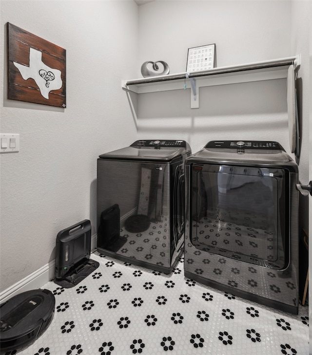 washroom featuring laundry area, baseboards, and washer and dryer