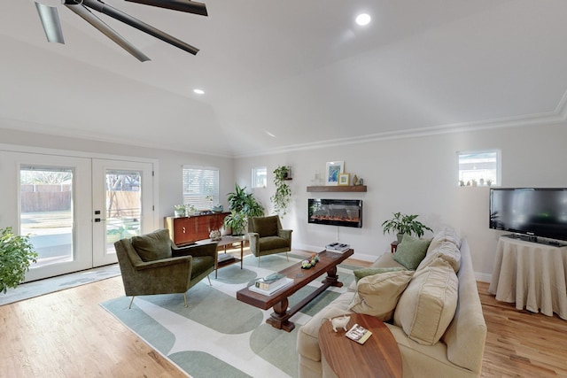 living room featuring french doors, lofted ceiling, crown molding, and light hardwood / wood-style floors