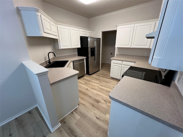 kitchen with sink, light hardwood / wood-style flooring, appliances with stainless steel finishes, white cabinets, and kitchen peninsula