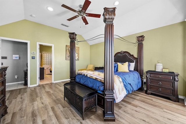 bedroom featuring light hardwood / wood-style flooring, vaulted ceiling, ceiling fan, and ensuite bathroom