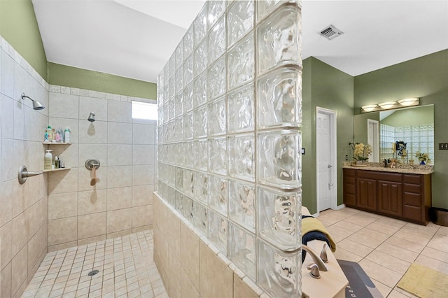 bathroom featuring tiled shower, tile patterned floors, and vanity