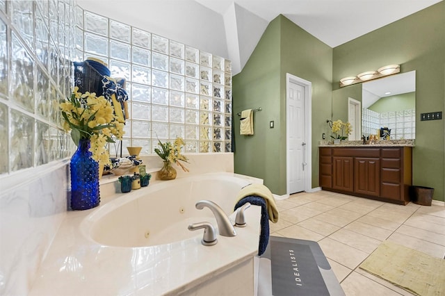 bathroom with tile patterned floors, vanity, and tiled tub