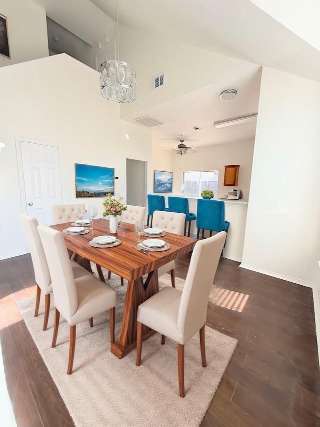 dining space featuring ceiling fan with notable chandelier, high vaulted ceiling, and dark hardwood / wood-style floors