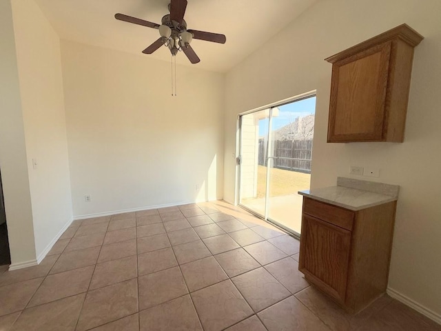 unfurnished dining area featuring light tile patterned flooring and ceiling fan