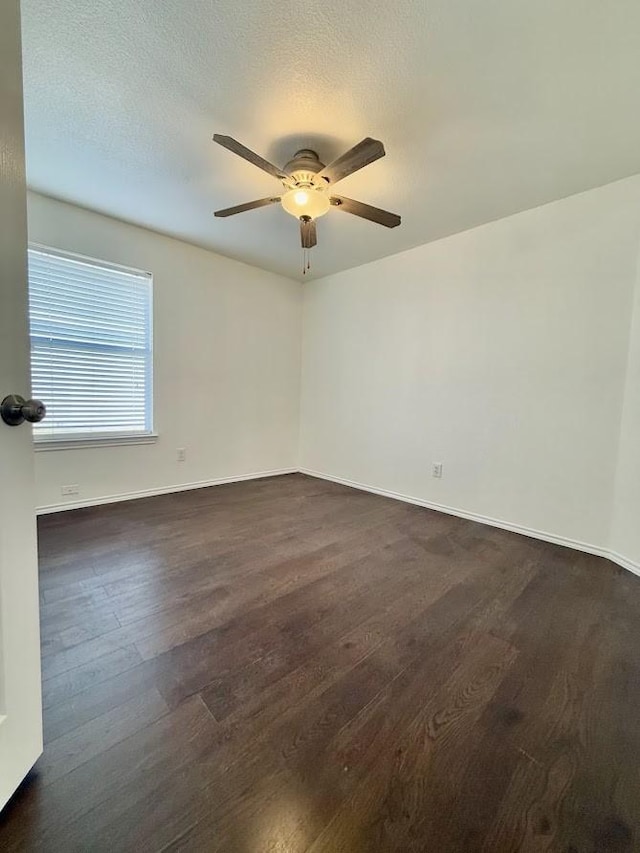 unfurnished room featuring dark wood-type flooring and ceiling fan