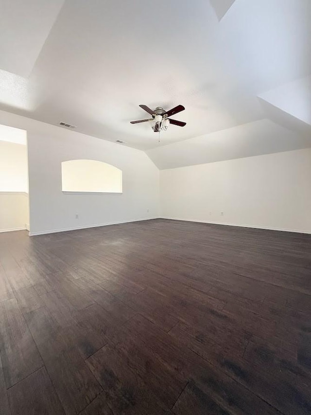 spare room with dark wood-type flooring, vaulted ceiling, and ceiling fan