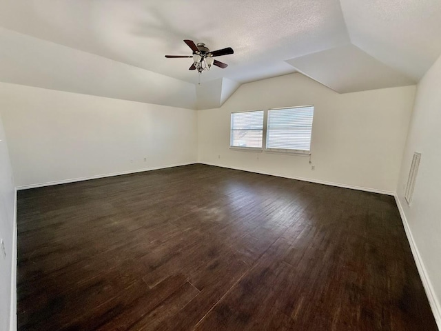 bonus room featuring ceiling fan, lofted ceiling, dark hardwood / wood-style floors, and a textured ceiling