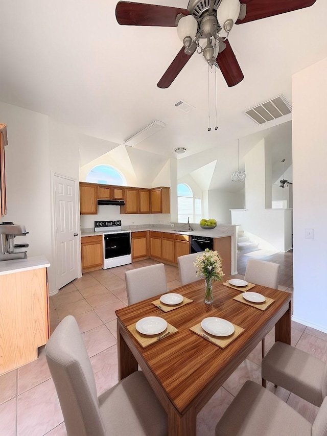 tiled dining room featuring ceiling fan, lofted ceiling, and sink