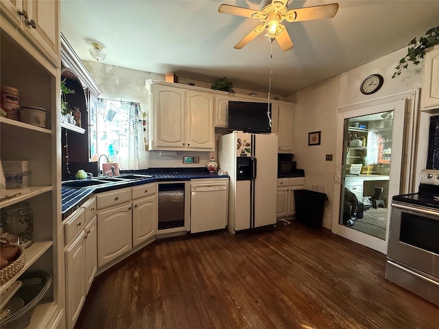 kitchen featuring white appliances, dark countertops, dark wood-style flooring, open shelves, and a sink