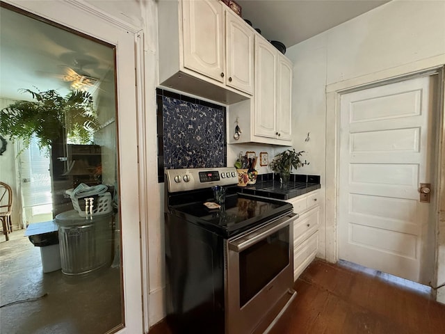 kitchen with stainless steel electric range oven, dark hardwood / wood-style floors, and white cabinets