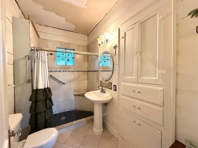 bathroom with toilet, tile patterned floors, and walk in shower