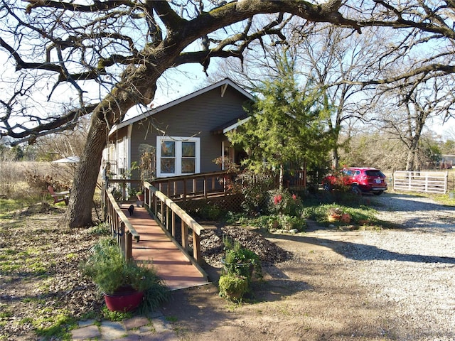 view of front of house featuring gravel driveway and a wooden deck