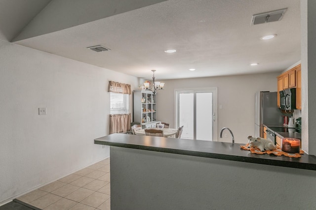 kitchen featuring light tile patterned flooring, lofted ceiling, sink, decorative light fixtures, and a chandelier