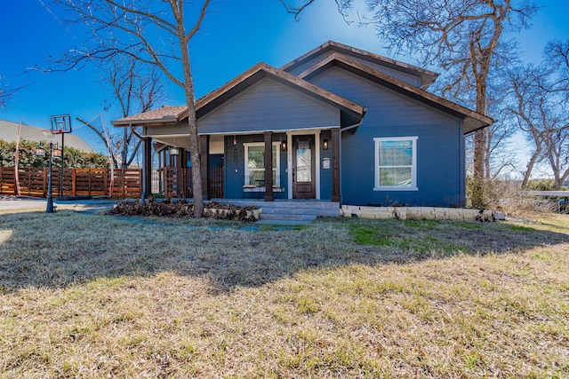 view of front of property with a porch, a front yard, and fence