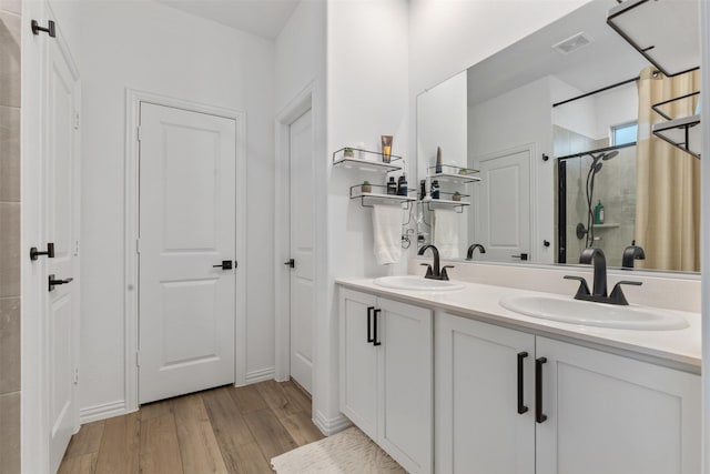 bathroom with vanity, hardwood / wood-style flooring, and walk in shower