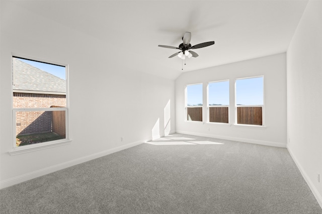 carpeted spare room with ceiling fan and lofted ceiling