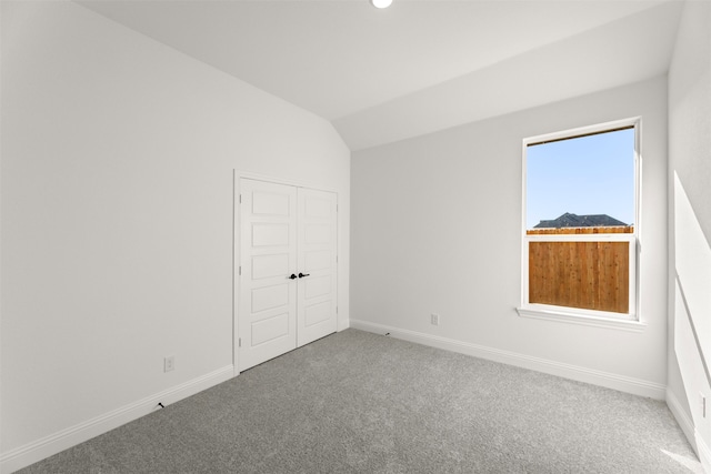 empty room with lofted ceiling and carpet