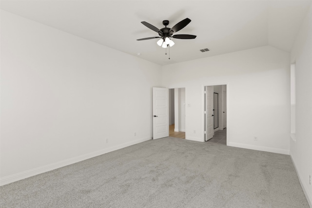 carpeted spare room featuring lofted ceiling and ceiling fan