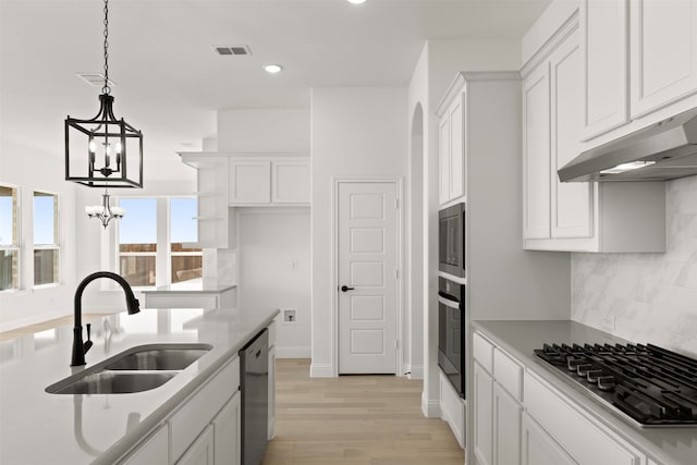 kitchen featuring stainless steel appliances, sink, hanging light fixtures, and white cabinets