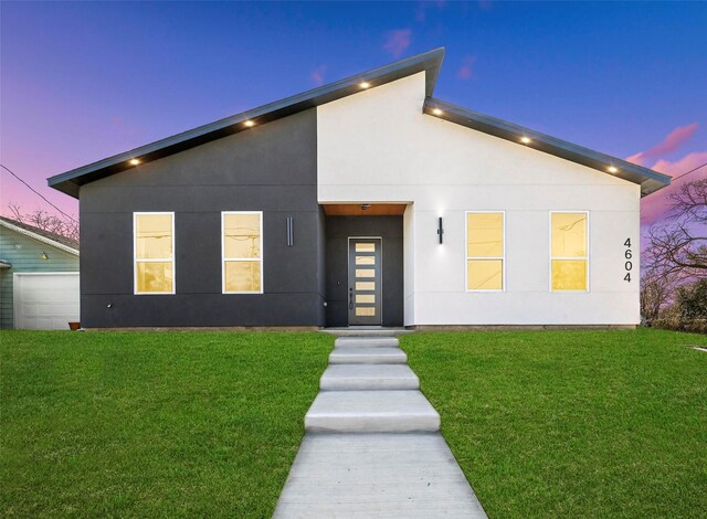 view of front of home with a garage and a front lawn