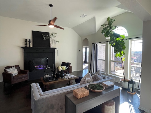 living room featuring dark hardwood / wood-style flooring, vaulted ceiling, and ceiling fan