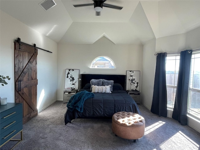 bedroom featuring ceiling fan, a barn door, vaulted ceiling, and dark colored carpet