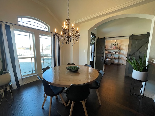 dining space with arched walkways, vaulted ceiling, a barn door, and a wealth of natural light
