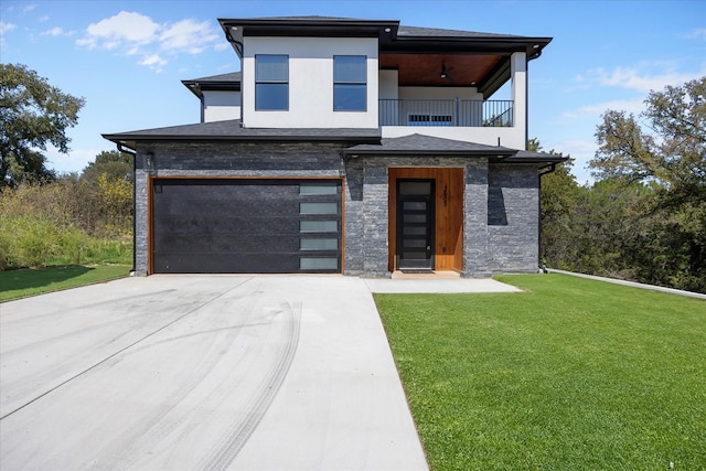 view of front of house featuring a garage, a balcony, and a front lawn