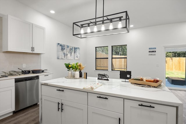 kitchen with hanging light fixtures, stainless steel dishwasher, plenty of natural light, decorative backsplash, and white cabinets