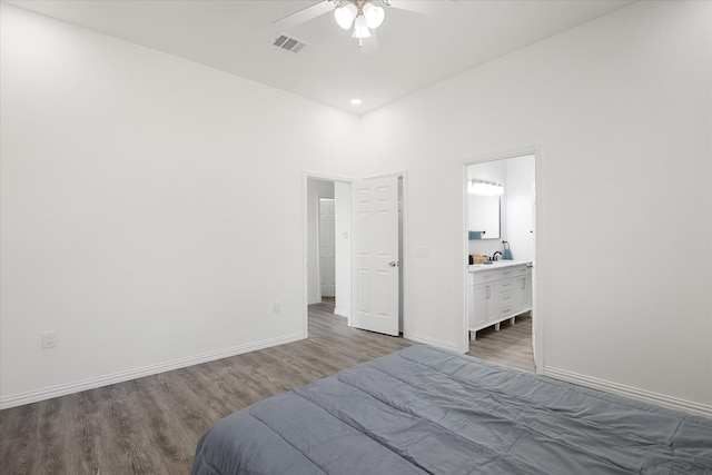 bedroom with connected bathroom, wood-type flooring, sink, and ceiling fan