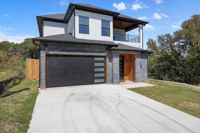 contemporary house featuring a garage, a balcony, and a front yard