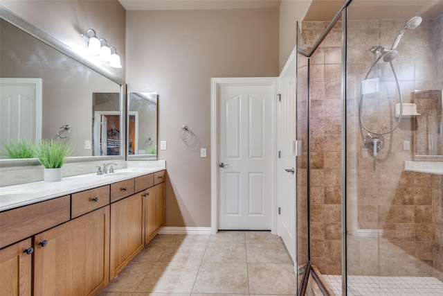 bathroom featuring a shower with door, vanity, and tile patterned flooring