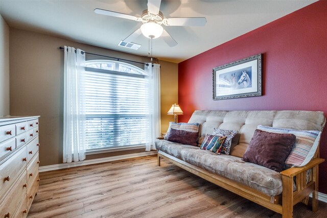 living room with ceiling fan and light wood-type flooring