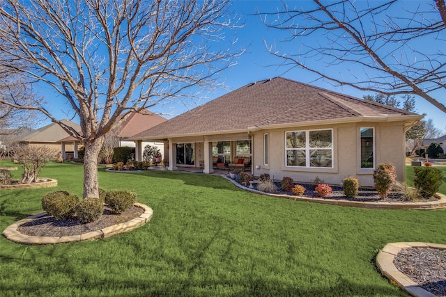 rear view of property featuring a yard and a patio area