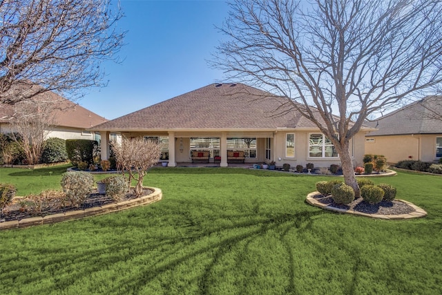 rear view of property featuring a lawn