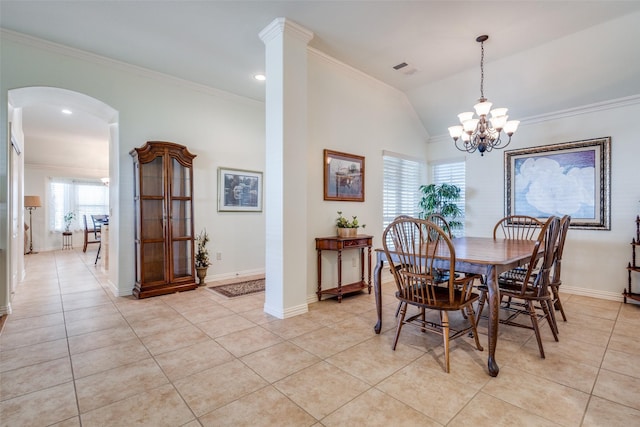 tiled dining area featuring vaulted ceiling, ornamental molding, and a notable chandelier