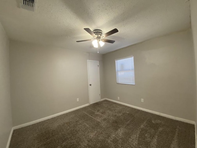 carpeted empty room with ceiling fan and a textured ceiling