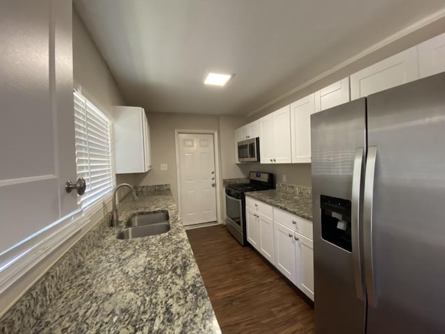 kitchen with sink, light stone countertops, white cabinets, and appliances with stainless steel finishes